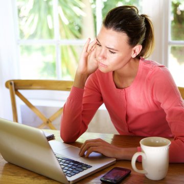 advanced system repair system optimizers woman in red blouse in front of laptop wondering
